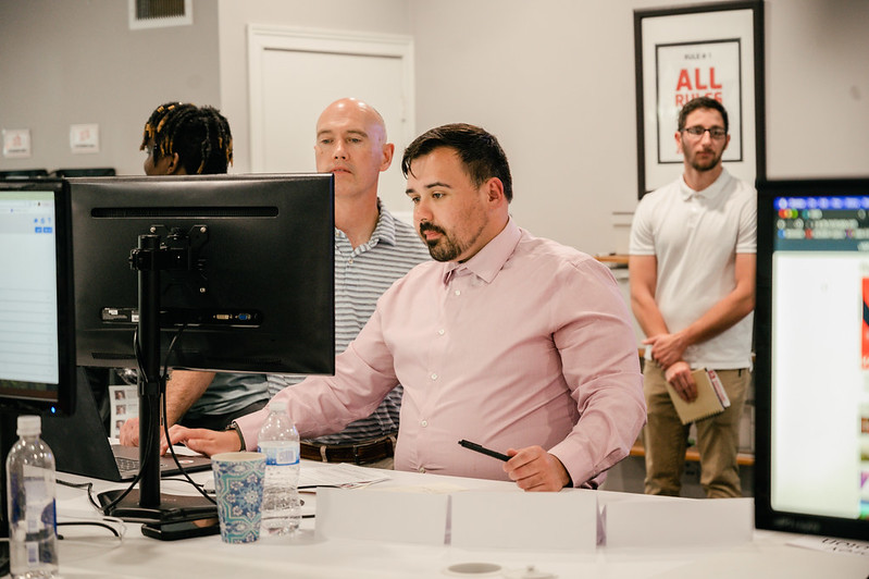 Two men focused on content on a computer screen. 